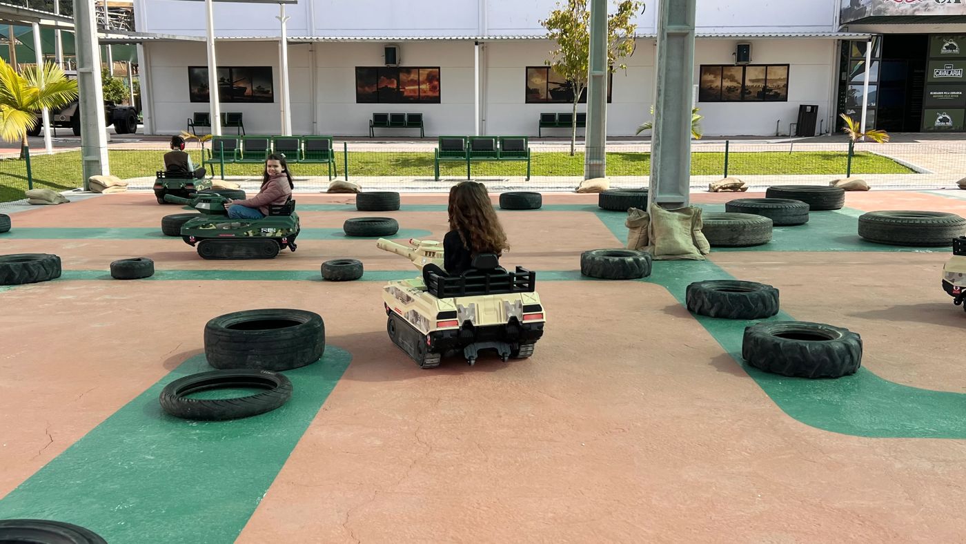 Crianças pilotando mini tanques na pista do Blindado do Dudinha