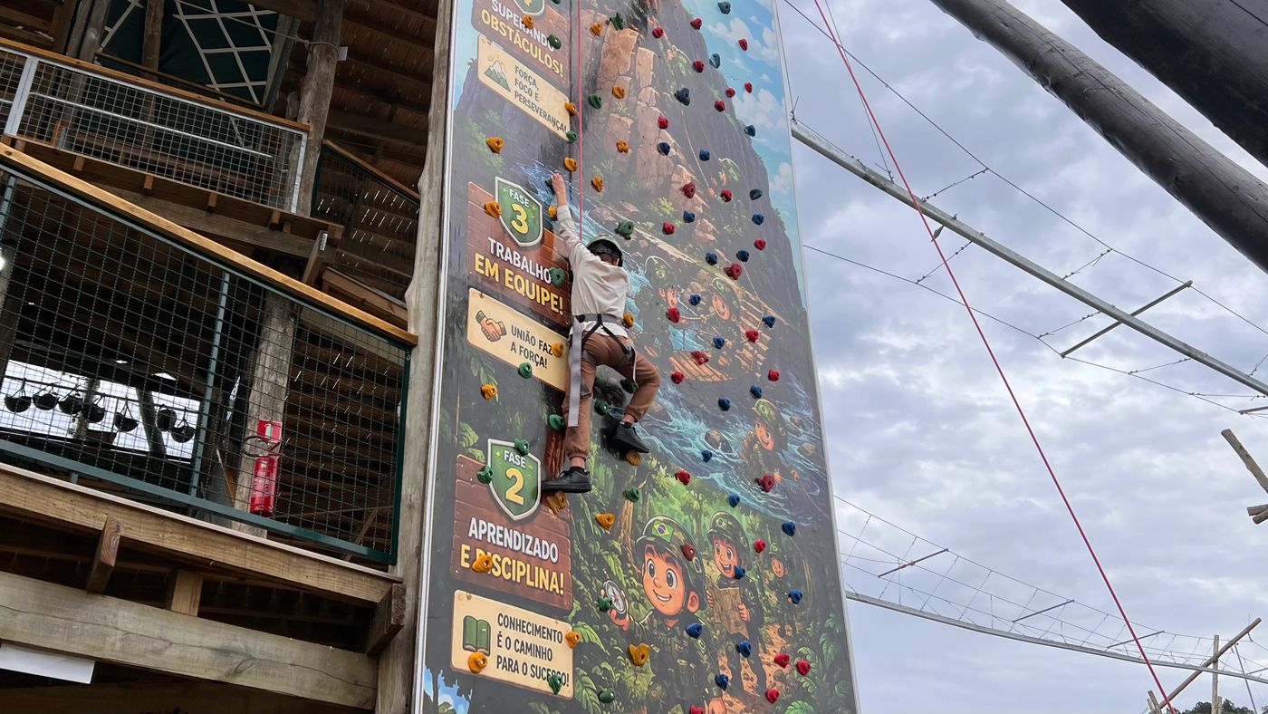 Criança subindo a parede de escalada ilustrada com as fases da jornada